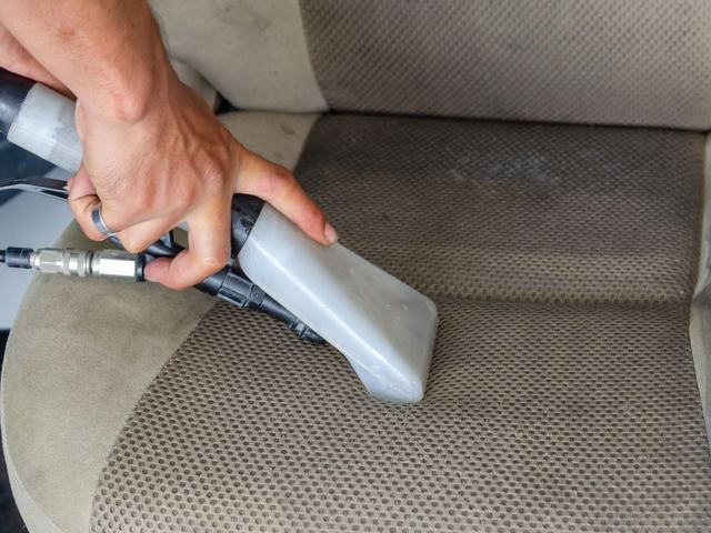 An extractor deep-cleaning a fabric car seat