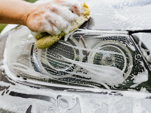 Suds and a sponge worked over a car headlight